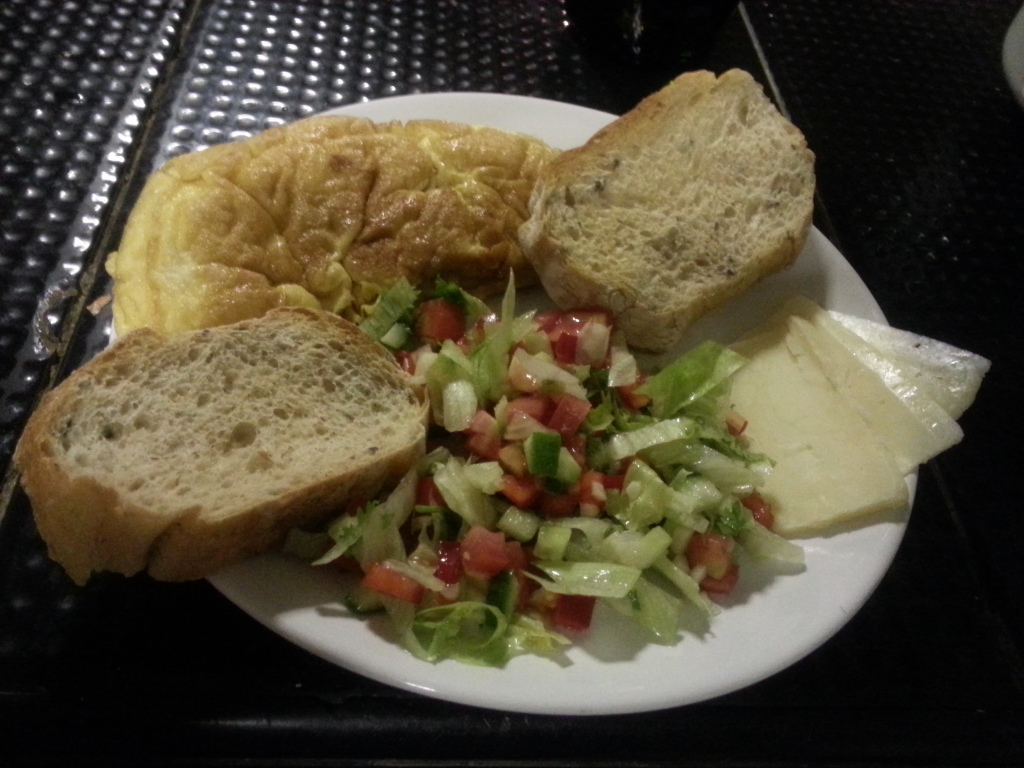 An omelet, a toast and a salad. The classical breakfast.