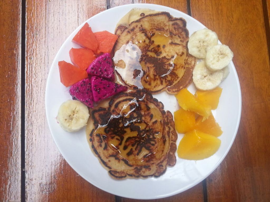 Pancake with tropical fruits. Banana, mango, dragon fruit and papaya.